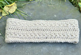 textured star stitch crochet headband laid flat on a grey stone surface thumbnail
