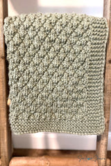 olive green knitted seersucker throw blanket draped over a wooden ladder display thumbnail