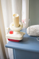 yarn ball winder attached to a dresser with yarn in background thumbnail