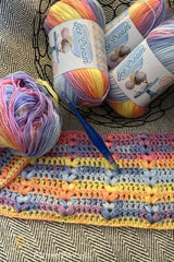 crocheted throw made with pastel yarn with colorful shades thumbnail