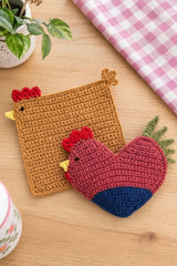 handmade chicken and rooster crochet trivet set on a wooden table with a pink cloth thumbnail