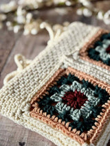 handmade crochet hearthside book sleeve made with modern granny squares in multicolor yarn thumbnail