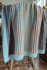 crochet baby blanket draped over a wooden chair thumbnail