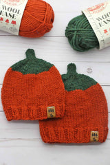 two knitted orange pumpkin beanies with orange and green yarn skeins thumbnail
