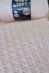 close up of baby soft skein of yarn and crochet baby blanket thumbnail