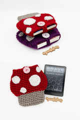red toadstool mushroom-shaped crocheted sleeve next to kindle reader thumbnail