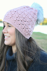 woman wearing a dusty pink crocheted beanie with a fur pom-pom thumbnail