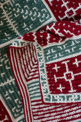 handmade mosaic crochet blanket featuring snowflake squares in red green and white yarn thumbnail