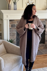 front view of woman wearing cardigan holding cup of coffee thumbnail