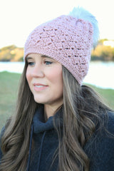 woman wearing a dusty pink crocheted beanie with a fur pom-pom thumbnail