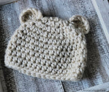 cream crocheted chunky bear beanie with ears on a wood background thumbnail