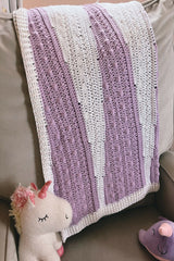 Purple and white baby blanket draped on a chair thumbnail