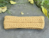 textured star stitch crochet headband laid flat on a grey stone surface surrounded by fallen autumn leaves thumbnail