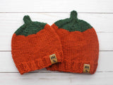 two knitted orange pumpkin beanies with orange and green yarn skeins thumbnail