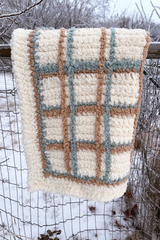 Plaid blanket hanging over fence. thumbnail