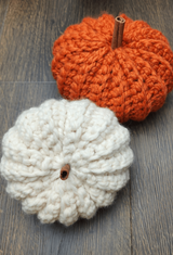 crocheted orange pumpkin next to a white one thumbnail