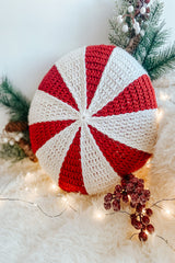 handmade peppermint wheel crochet pillow surrounded by branches and lights thumbnail