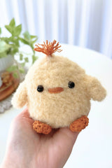 Fluffy chick stuffed animal in a person's hand thumbnail