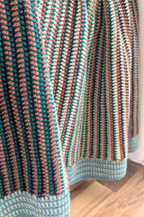 crochet baby blanket draped over a wooden chair thumbnail