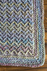 extreme close-up of corner of crochet blanket showing textured herringbone stitch thumbnail