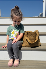 Child sitting next to tote bag on stairs thumbnail