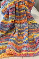 crocheted blanket made with pastel yarn with colorful shades thumbnail