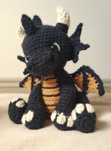 crochet amigurumi stuffed animal of a dragon alternate colors (black, orange, and cream) thumbnail