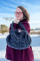 woman holding a dark blue crocheted hobo handbag with a button closure thumbnail