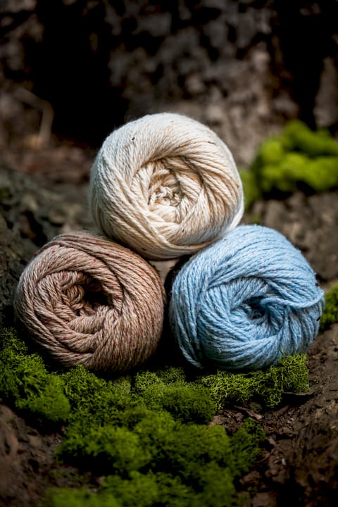 Woman winding ecofriendly yarn in craft room