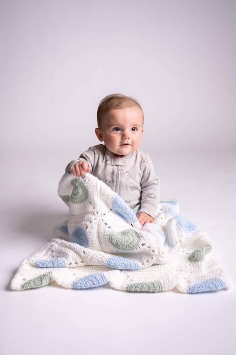 Mature woman sorting pastel baby yarns