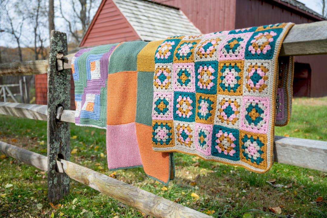 Hands crocheting multi-colored granny square