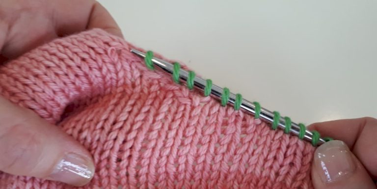 Woman picking up stitches on knitted swatch