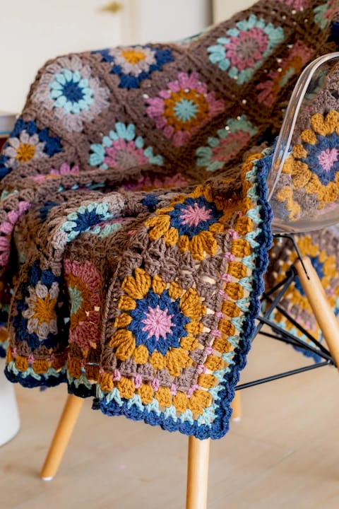 Crocheter smoothing a finished blanket border