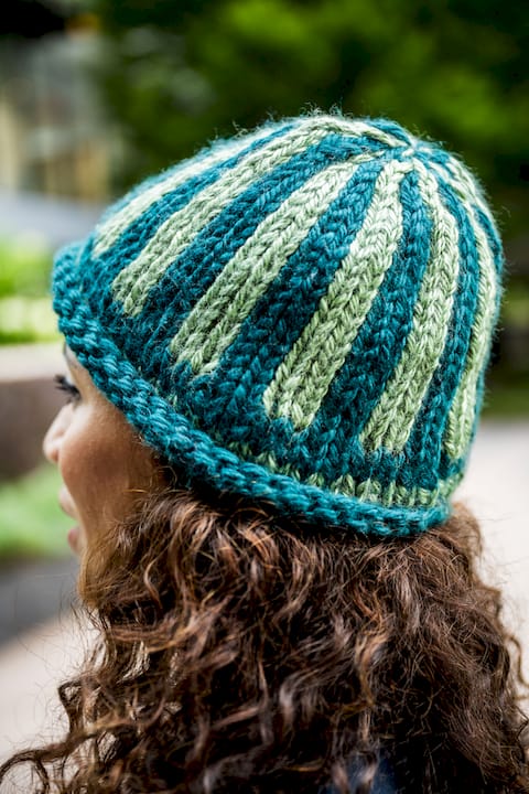 Older woman knitting a ribbed beanie